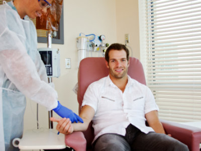 nurse inject at the right arm of man receiving chemotherapy at the hospital